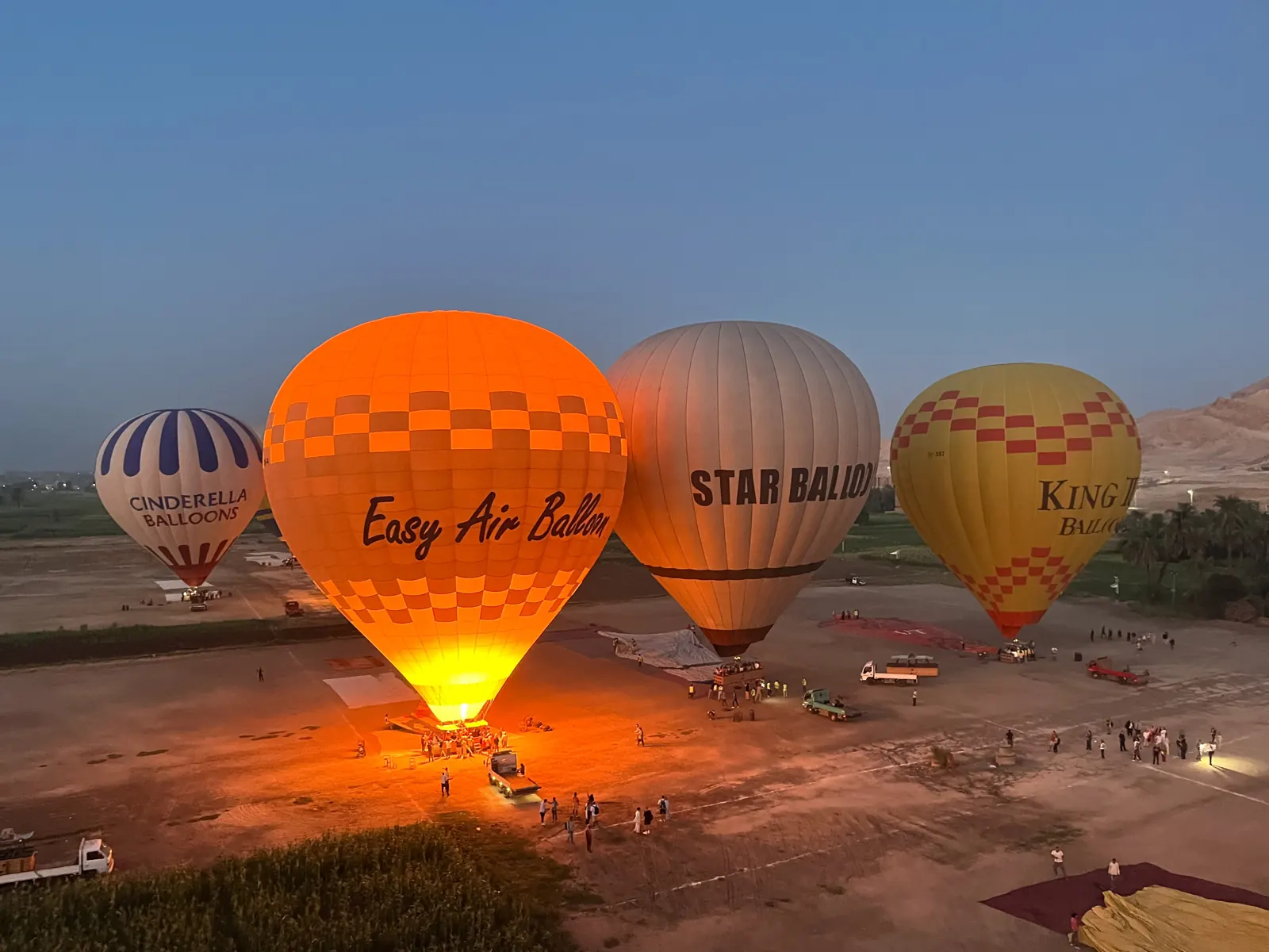 Hot air balloons rising over the hills of the Valley of the Kings at dawn
